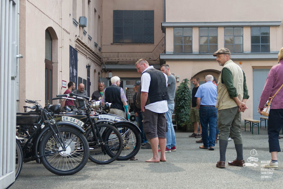 Motorräder und Besucher vor dem Museum