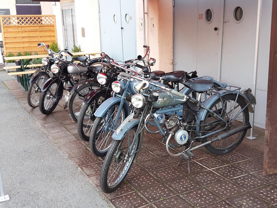 verschiedene Kleinmotorräder in Reihe vor dem Museum